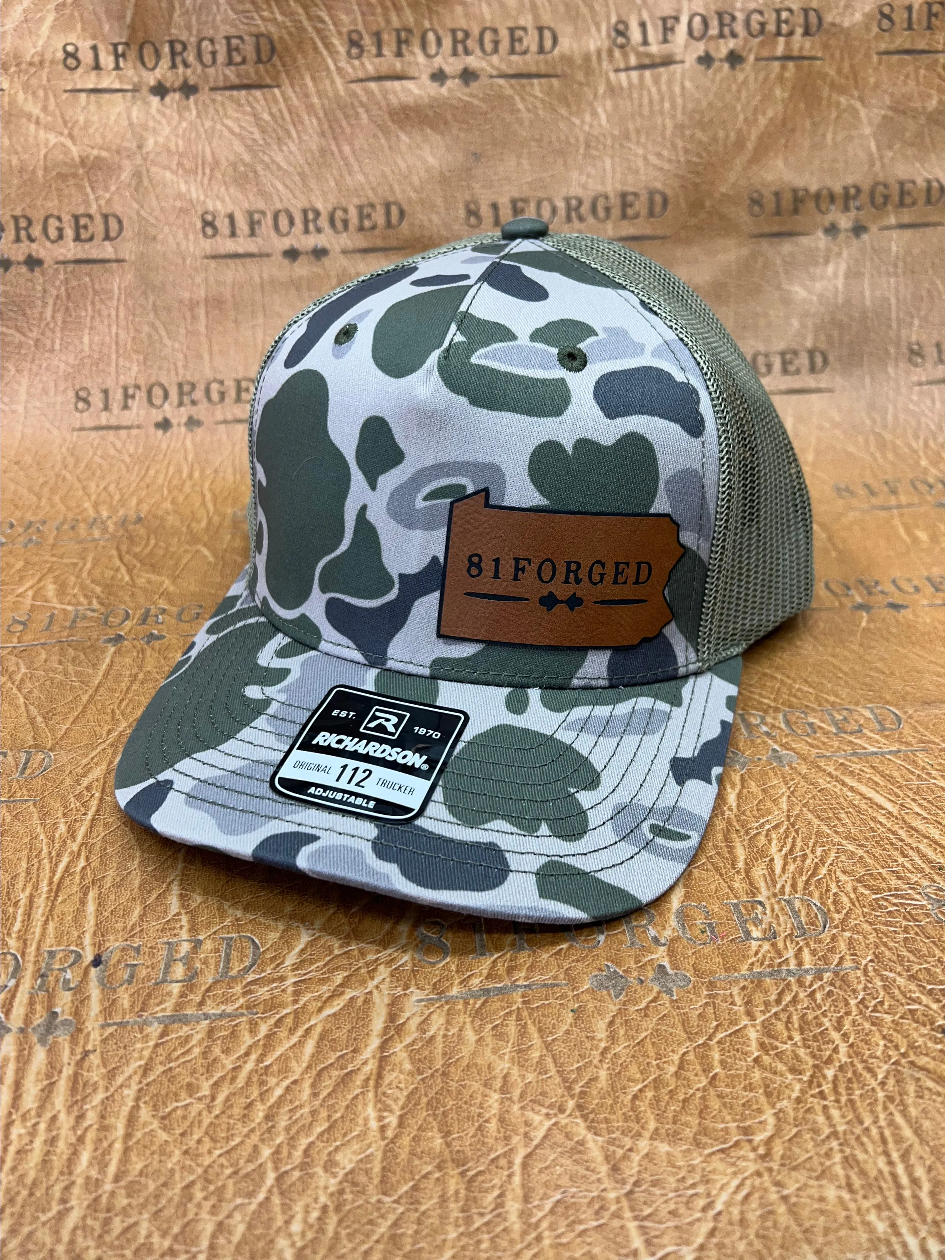 Product image for camo Richardson 112 leather patch hat with the 81Forged Logo.