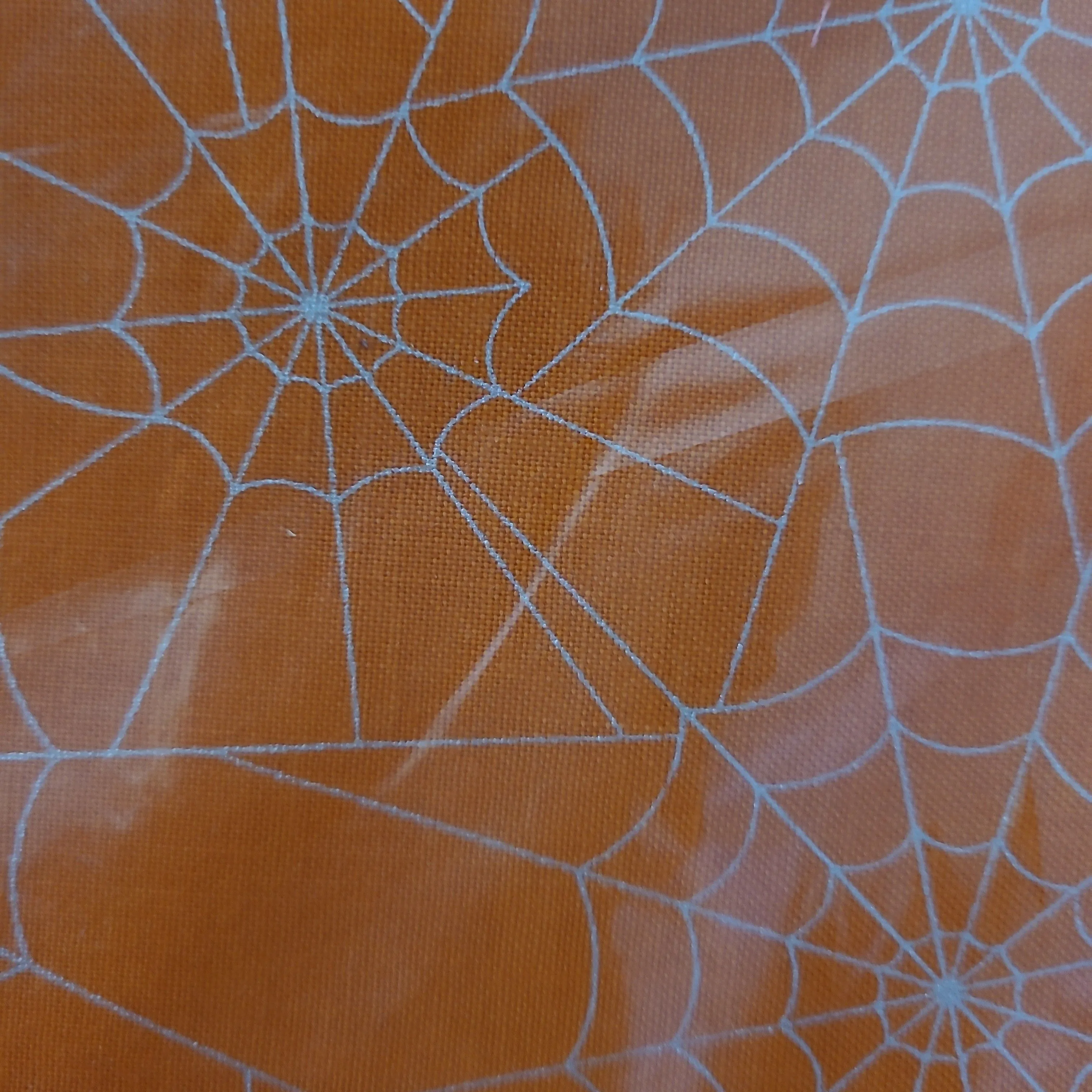 Product image for 1/2 yard.  orange with silver spiderwebs