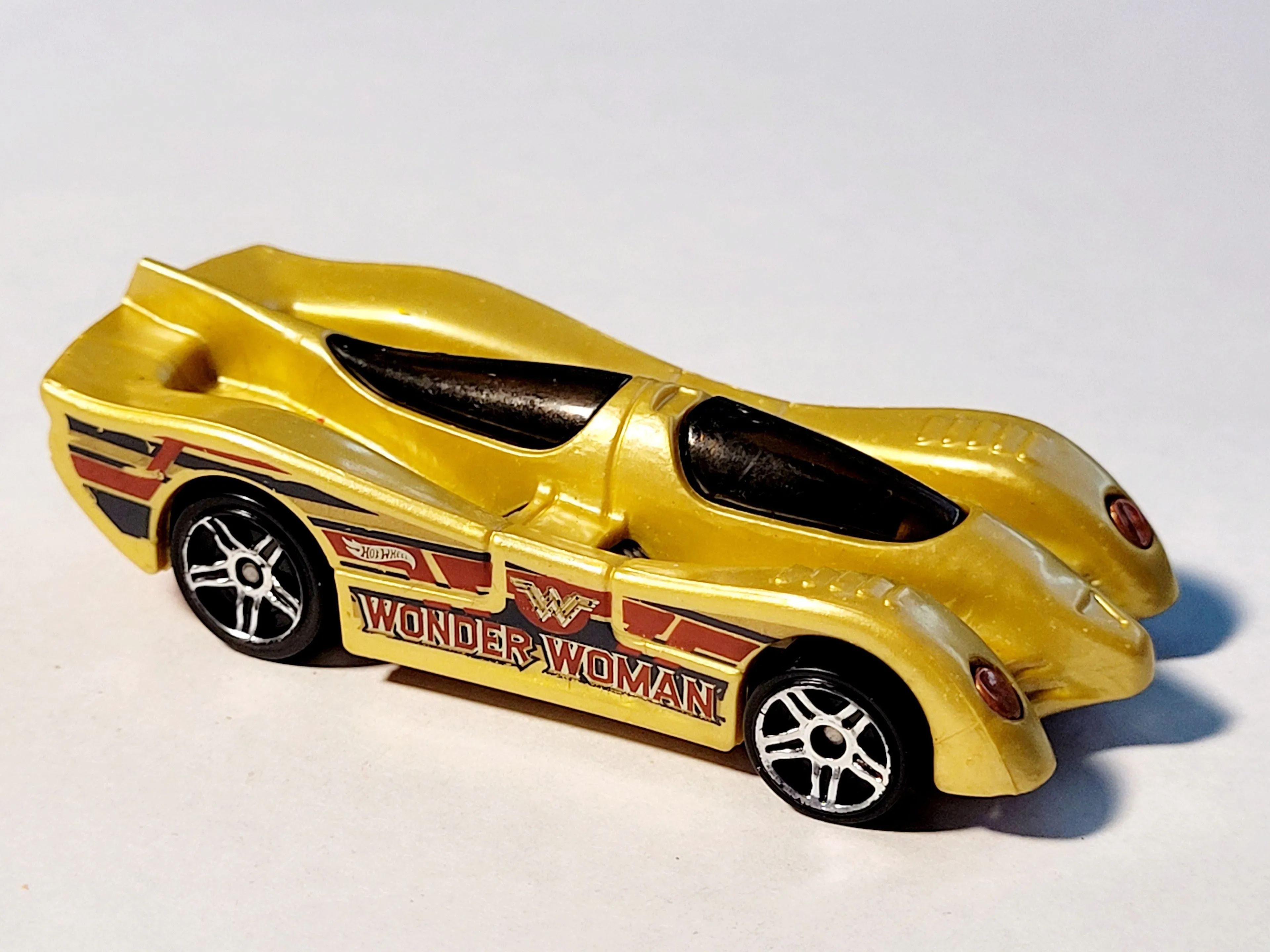 Product image for 2014 Hot Wheels Mattel Wonder Woman Power Pistons Gold #6/7 Die-Cast 1:64 Car.
The image displays a 