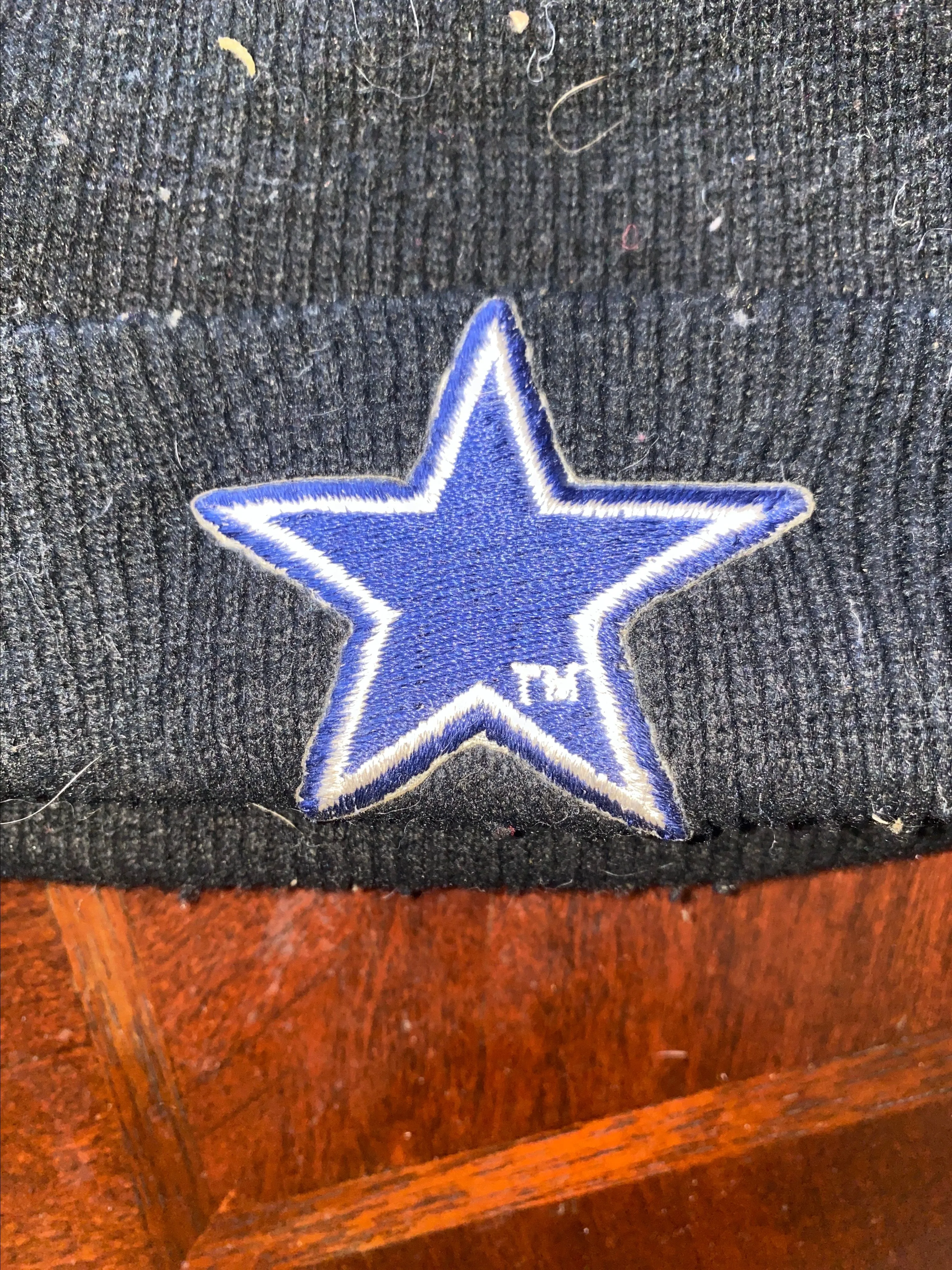 Product image for Dallas cowboys beanie cap used. Stylish black knit beanie featuring a striking blue star emblem. Per