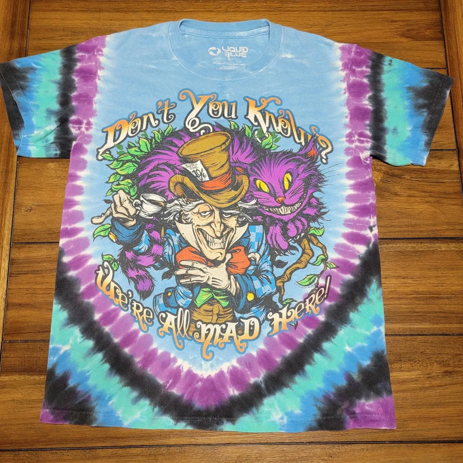 Product image for Liquid Blue Tie Dye Unisex Tee "We're All Mad Here" - Size Small
