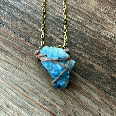 Blue crystal pendant necklaceStone is held together w/ twine/gold tone necklace